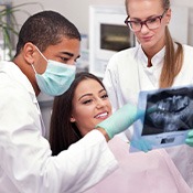 Dentist reviewing X-ray with smiling patient