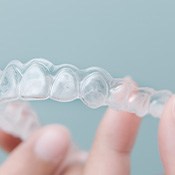 Closeup of patient holding clear aligner