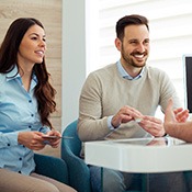 Dentist and couple talking in dental office