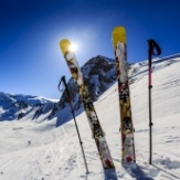 Skis and ski poles standing up in the snow
